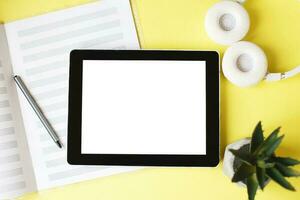 Top view open music book, headphones and a pen on a yellow background. mock up for music lessons photo