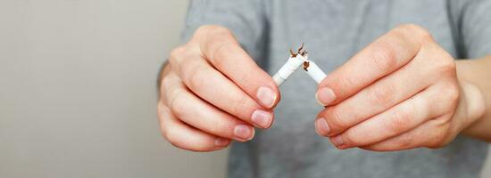 young woman holding broken cigarette in her hands close.banner photo