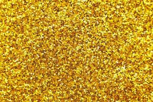 glittering background of golden sequins closeup. Sparkle festive texture photo