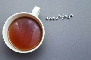 A cup of tea and word freelance made from plastic cubes of beads on gray background with copy space photo