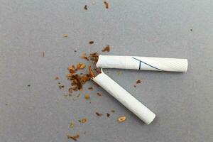 broken cigarette on gray background close. stop smoking concept photo