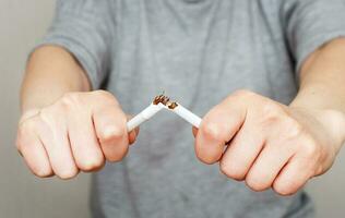 young woman holding broken cigarette in her hands close photo