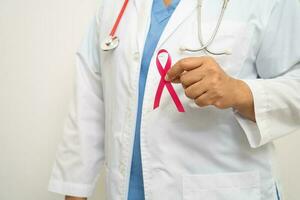 Breast cancer, Asian doctor woman with pink ribbon, symbol of World Breast Cancer Day. photo