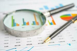 Magnifying glass on graph paper. Financial development, Banking Account, Statistics, Investment Analytic research data economy, Business concept. photo