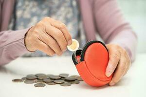 asiático mayor o mayor antiguo dama mujer participación contando moneda dinero en cartera. pobreza, ahorro problema en Jubilación. foto