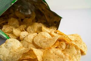 Potato chips, delicious spicy for crips, thin slice deep fried snack fast food in open bag. photo