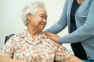 Caregiver help Asian elderly woman patient with love, care, encourage and empathy at nursing hospital, healthy strong medical concept. photo