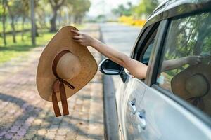 Happy enjoy and freedom in traveling trip with raised hand and holding hat outside of window car in summer vacation holiday. photo
