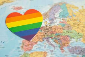 Bangkok, Thailand, June 1, 2022 Rainbow color heart on globe world map background, LGBT pride month celebrate annual in June, symbol of gay, lesbian, bisexual, transgender, human rights and peace. photo