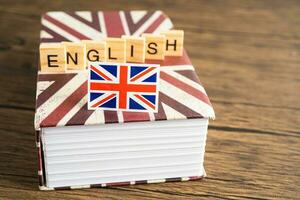 Word English on book with United Kingdom flag, learning English language courses concept. photo