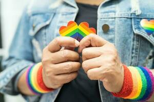 dama asiática con pulseras de la bandera del arco iris, símbolo del mes del orgullo lgbt celebran anualmente en junio las redes sociales de gays, lesbianas, bisexuales, transgénero, derechos humanos. foto