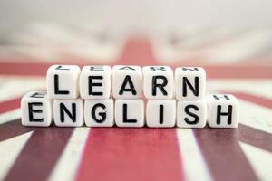 Word Learn English on book with United Kingdom flag, learning English language courses concept. photo