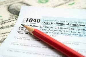 Tax Return form 1040 with USA America flag and dollar banknote, U.S. Individual Income. photo