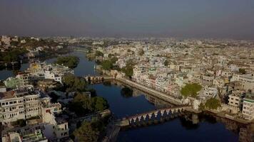 antenne visie 4k video door dar van meer pichola en stad paleis, udaipur, rajasthan, Indië