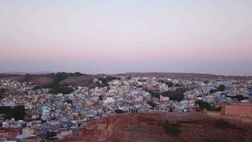 aéreo ver zumbido 4k de azul ciudad pueblo en jodhpur, rajastán, India en amanecer. video