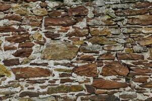 Old masonry made of red natural stone photo