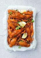 top view of cooked crawfish platter with lemons and spices photo