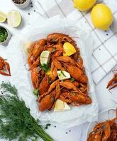 top view of cooked crawfish platter with lemons and spices photo