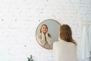 mujer mirando a el espejo, haciendo arriba en el Mañana foto