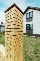 Fragment of a modern fence lined with decorative bricks in the old style photo