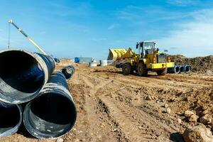 Wheel machine for loading performs work on laying large diameter pipes photo