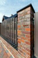 Fragment of a modern fence lined with decorative bricks in the old style photo