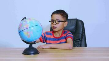 Asian boy looking at world map video