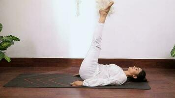 Video of a woman performing Ardha Halasana