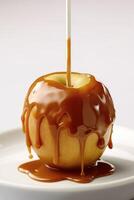 Delicious caramel apple wooden stick on plate. photo