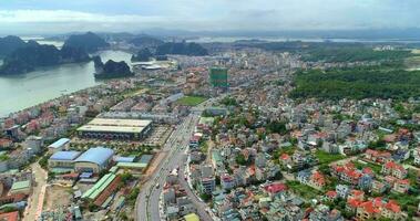 4k antenn se över stad och parkera med bai tho karst berg ha lång bukt. halong stad, vietnam video