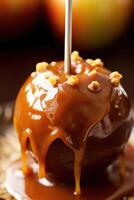 Delicious caramel apple wooden stick on plate. photo