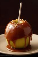 Delicious caramel apple wooden stick on plate. photo