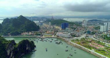 4k Aerial view over city and park with Bai Tho karst mountain Ha long bay. Halong City, Vietnam video