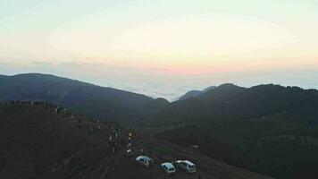 mensen op het beroemde uitkijkpunt van de Bakhmaro-zonsondergang kijken naar de zonsondergang boven de wolken in Georgië video