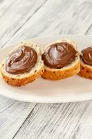 Slices of baguette with chocolate paste photo