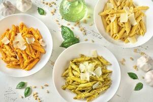 Penne pasta with various pesto sauces photo