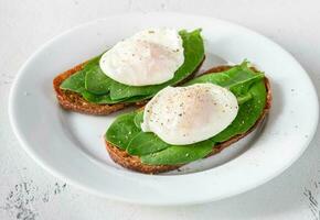 Sandwiches with spinach and poached egg photo