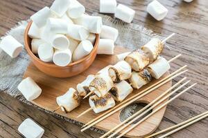 brochetas de malvavisco en la tabla de madera foto