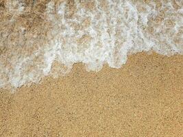 Ocean wave on sandy beach photo