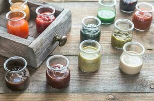 Assortment of sauces in the glass jars photo