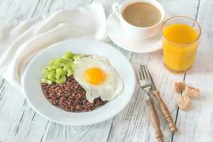Portion of red quinoa with fried egg and celery photo