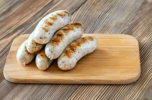 Grilled sausages on wooden board photo