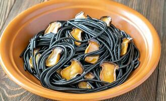 Black pasta with mushrooms photo