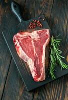 Raw T-bone steak with fresh rosemary photo