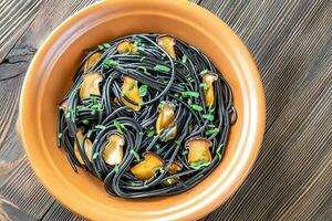 Black pasta with mushrooms photo