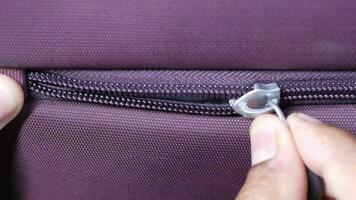 Hand in a zipper on a suitcase video