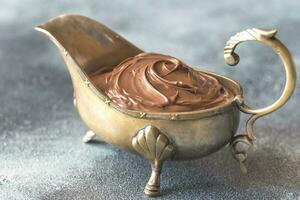 Vintage gravy boat with chocolate cream photo