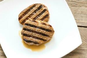 Beef steaks on the white square plate photo