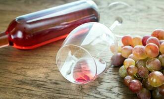 Glass of rose wine with bunch of grape photo