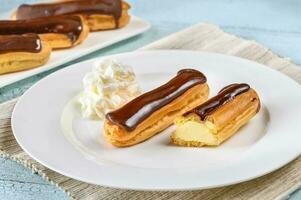 Eclairs with chocolate topping photo